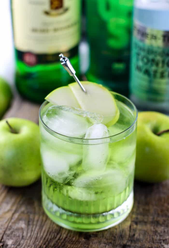 Irish Sour Apple Cocktail with an apple garnish in front of Jameson Irish Whiskey bottle