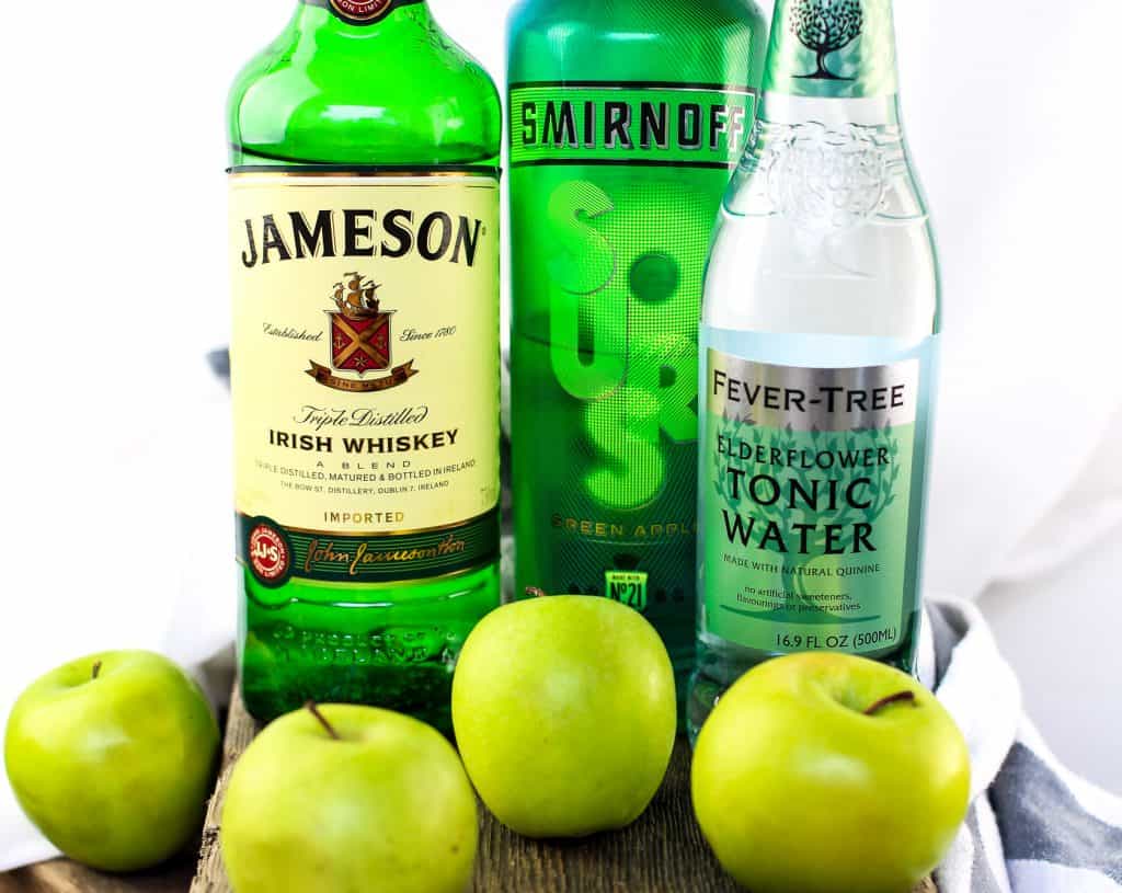 Irish Sour Apple Cocktail ingredients jameson irish whiskey, smirnoff sour, and fevertree tonic water by green apples
