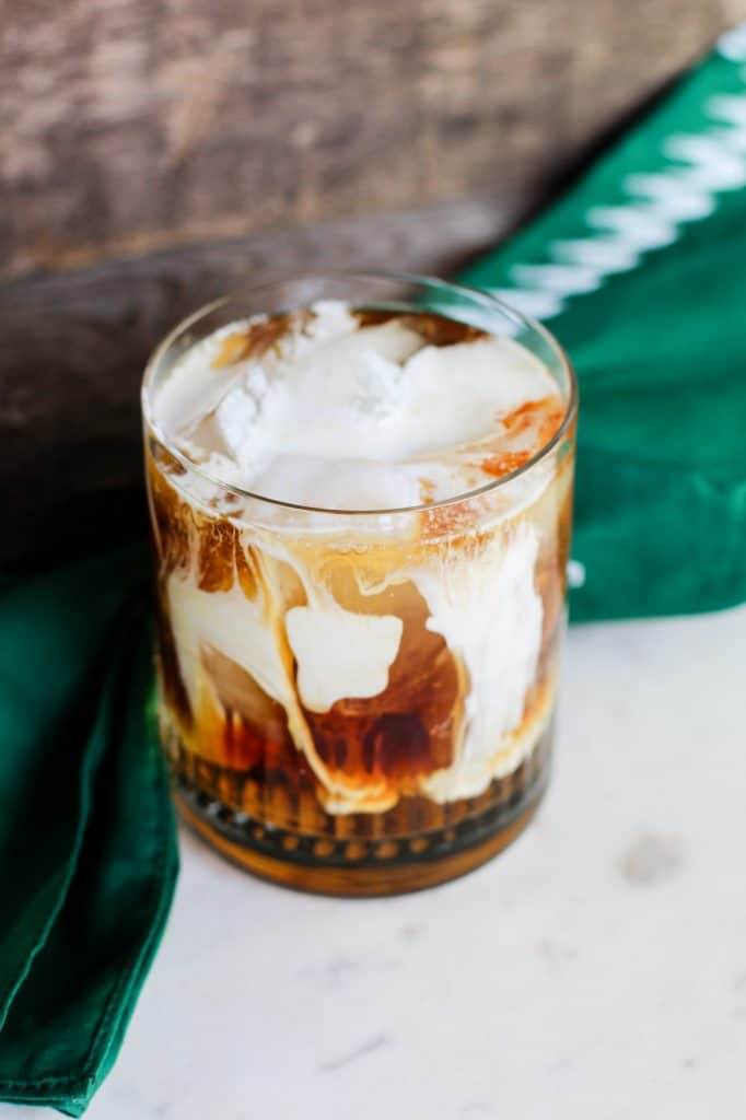 Iced Irish Coffee in a rocks glass by a green napkin