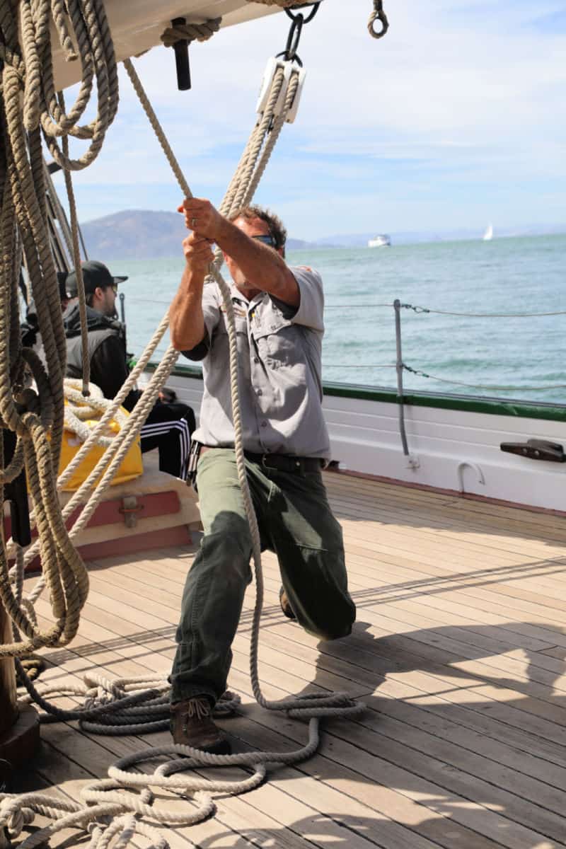 Ranger working the ropes on the 1891 Scow Schooner Alma while sailing in the San Francisco Bay