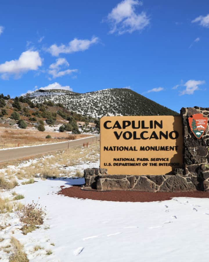 Capulin Volcano National Monument entrance sign in foreground with Capulin Volcano in the Background