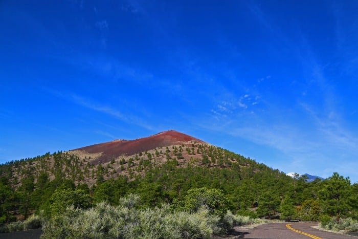 wide view of Sunset Crater Volcano in Arizona with a bright blue background. 