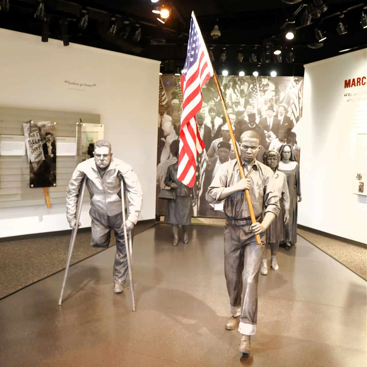 two statues of people marching with an American Flag in the Selma to Montgomery interpretative Center