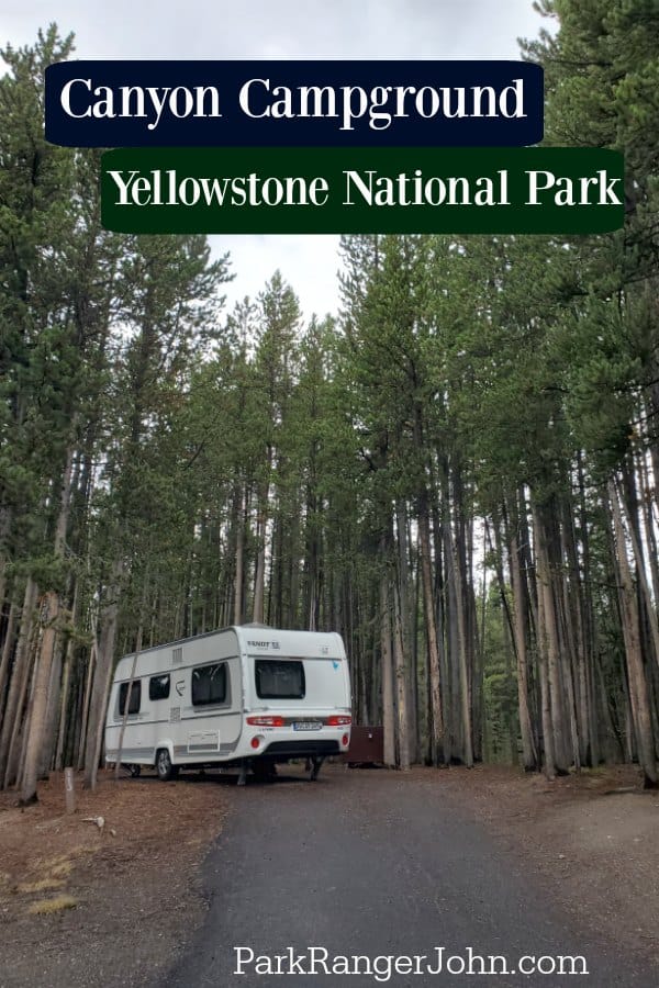 White rv parked in a campsite surrounded by trees in the Canyon Campground, Yellowstone National Park. 