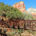 Text "Best Hikes in Zion National Park by ParkRangerJohn.com" with photo of bridge over the virgin River and Angels Landing in the background