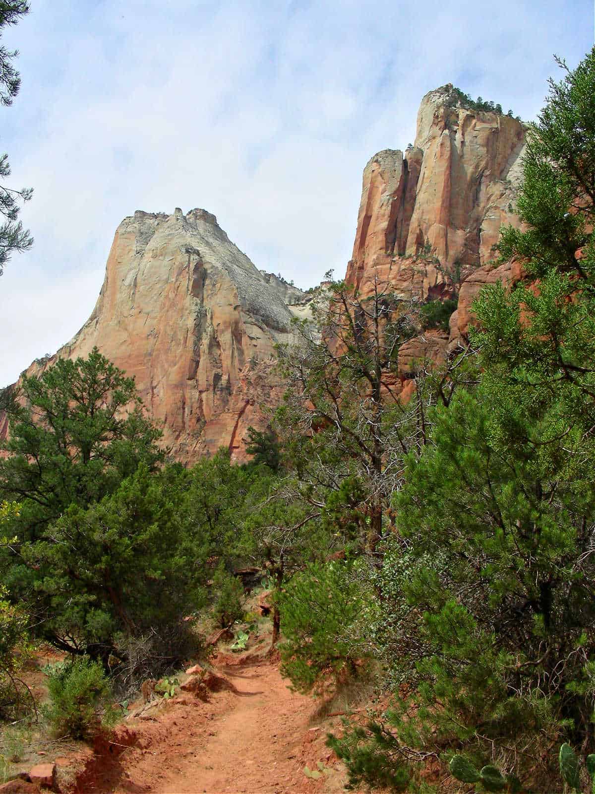 Sand bench trail in the foreground with the Court of the Patriarchs in the background at Zion National Park
