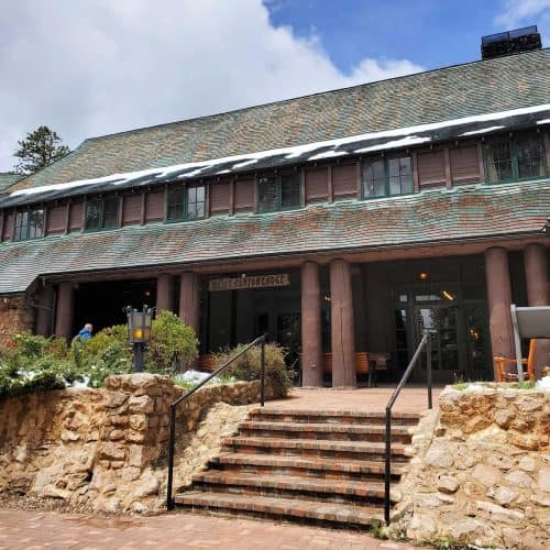 Front Entrance to Bryce Canyon Lodgewith stairs leading up to the entrance door of the stone lodge with a green roof