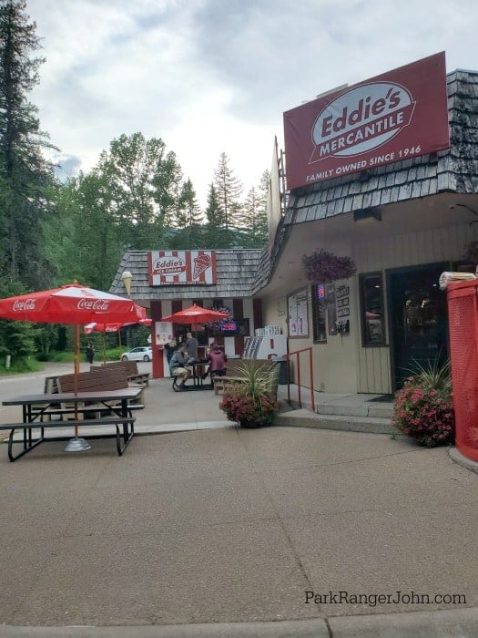 Eddies mercantile entrance, picnic tables with umbrellas and eddie's ice cream in the background