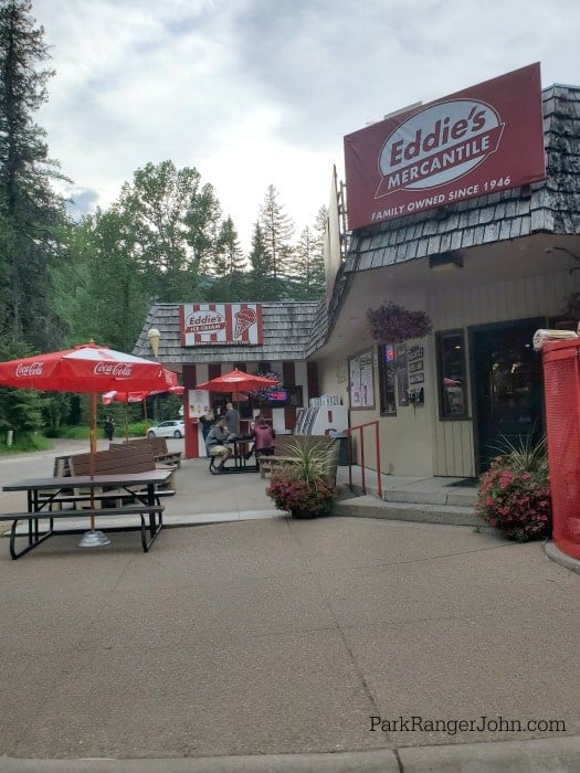 Eddies mercantile entrance, picnic tables with umbrellas and eddie's ice cream in the background 