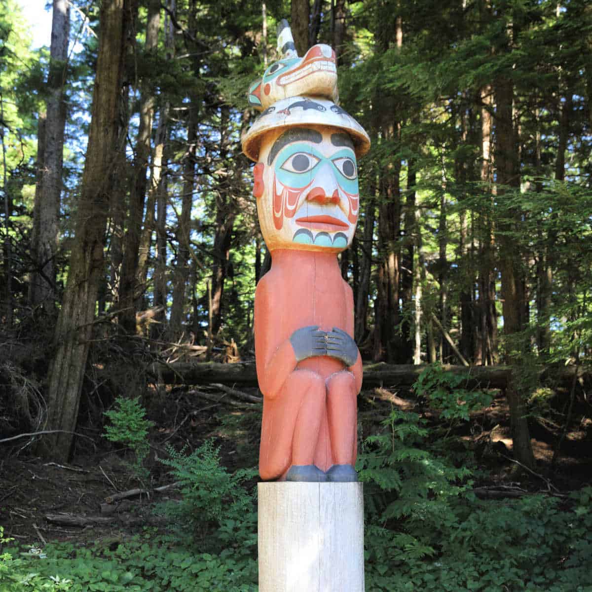 Man wearing bear hat totem pole at Totem Bight State Historical Park in Ketchikan Alaska