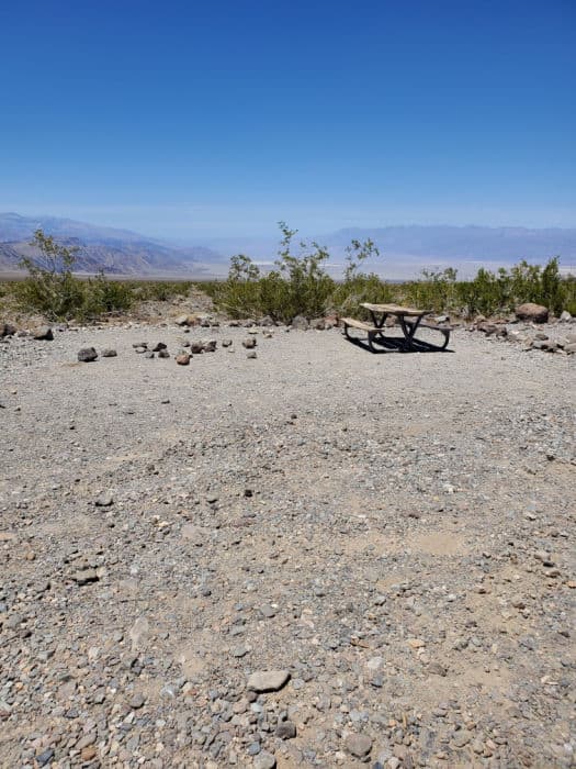 Gravel campsite with picnic table overlooking mountains in Death Valley