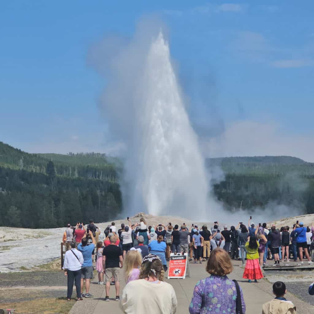 Park visitors statnding around Old Faithful Geyser, a must see in Yellowstone National Park