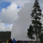 Photo of Old Faithful erupting with park visitors watching with text "Old Faithful Yellowstone National Park by ParkRangerJohn.com"
