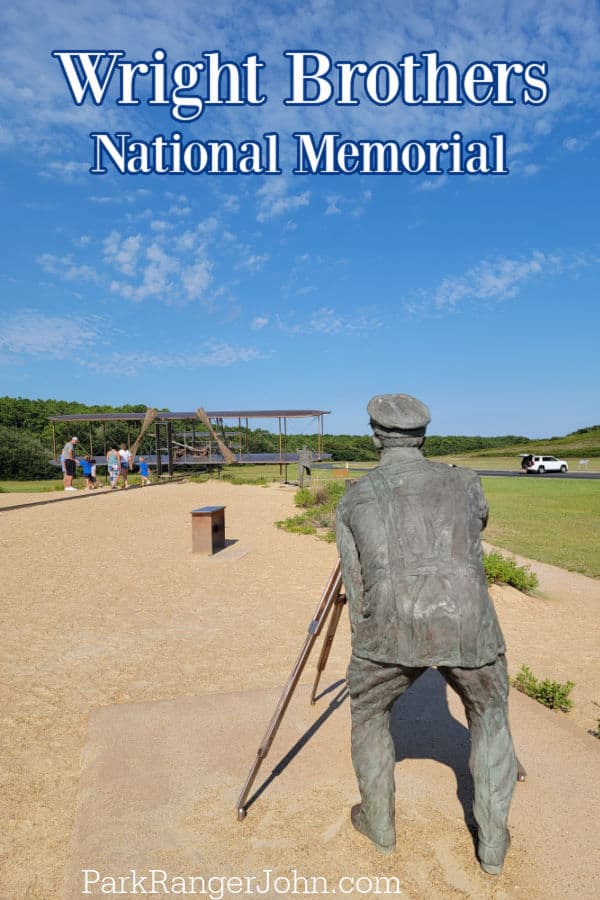 Wright Brothers National Memorial text over a statue of a man taking a photo of a plane