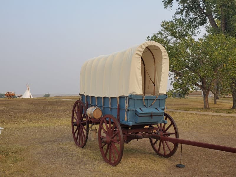 Historic blue prairie wagon with cloth cover in Fort Laramie National Historic Site