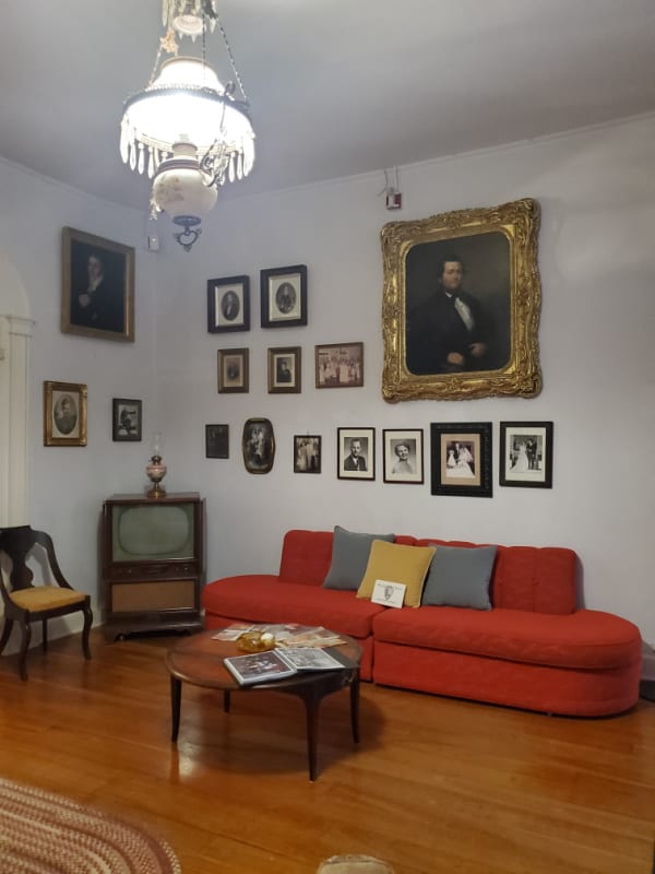 living room with couch, tv, and family photos on the wall at Oakland Plantation in Cane River Creole NHP