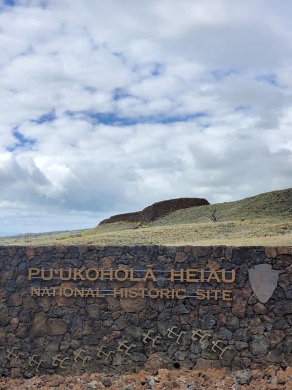 Pu`ukoholā Heiau National Historic Site sign with the heiau in the backgorund