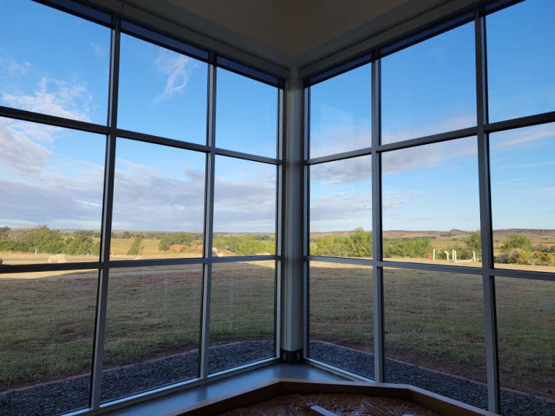 Looking out a large window from the visitor center to the plains at Washita Battlefield NHS