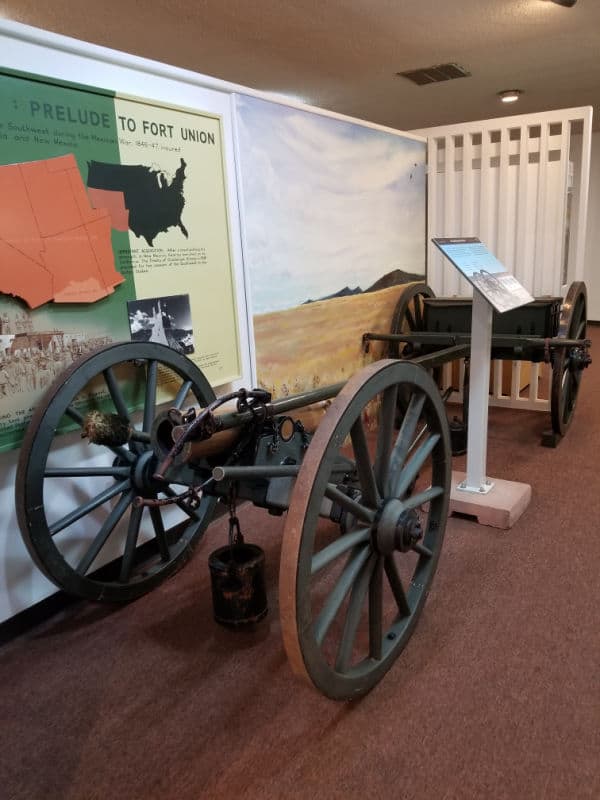 historic cannon and interpretive information at fort union national monument visitor center