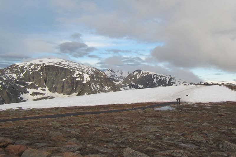 Paved trail to an interpretive panel with Rocky Mountains in the background 