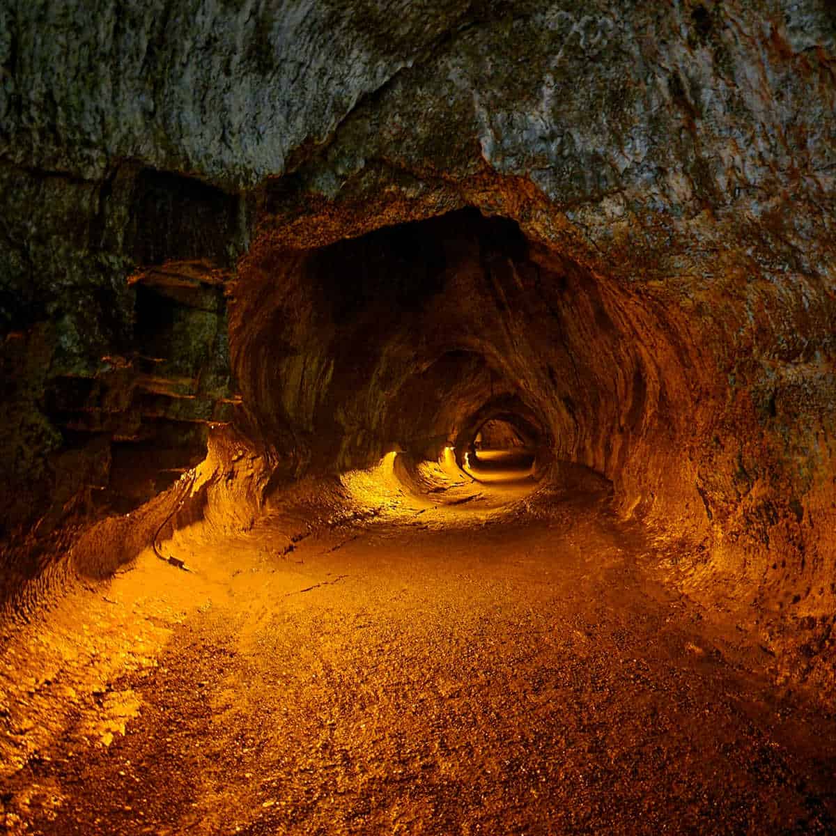 Looking into Thurston Lava tubes with lights illuminating the trail