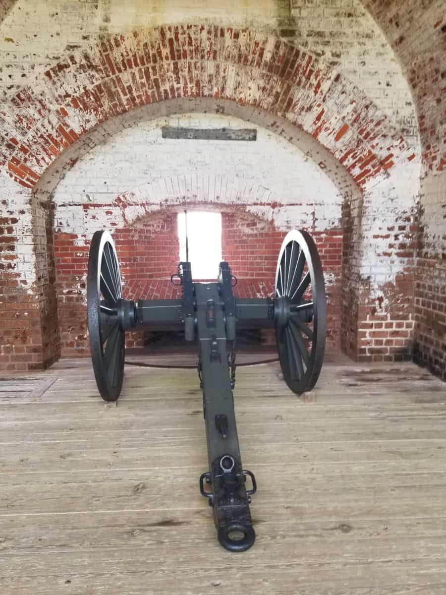 Historic cannon inside of Fort Pulaski with red bricks