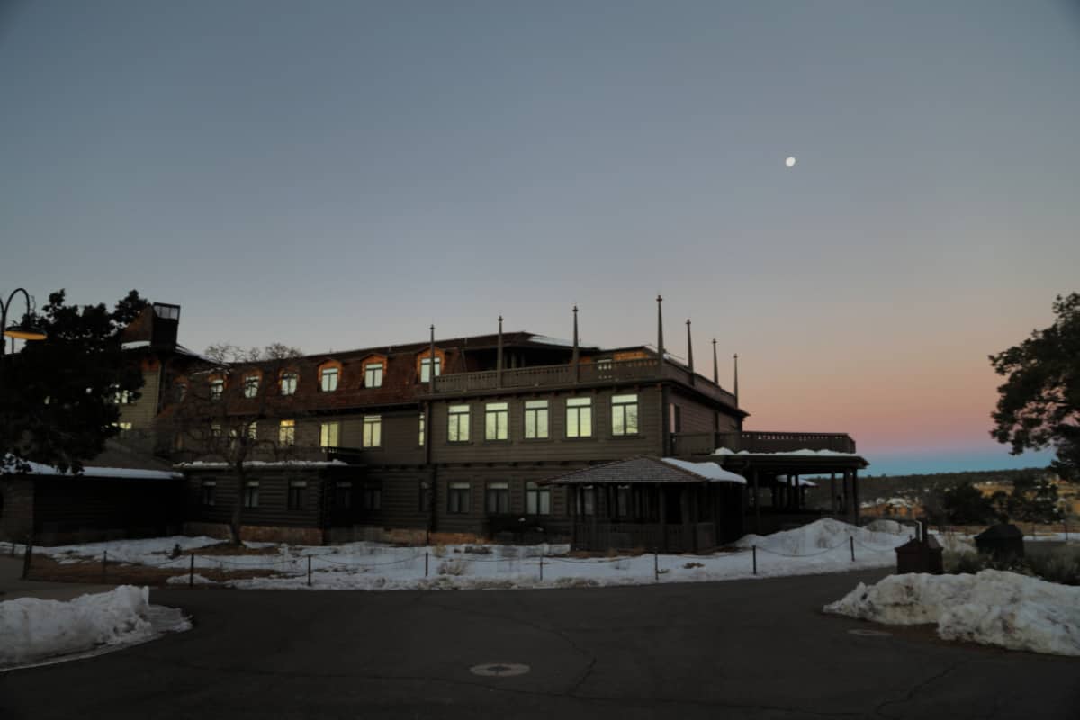 sunset colors and the moon over the exterior of the El Tovar Hotel