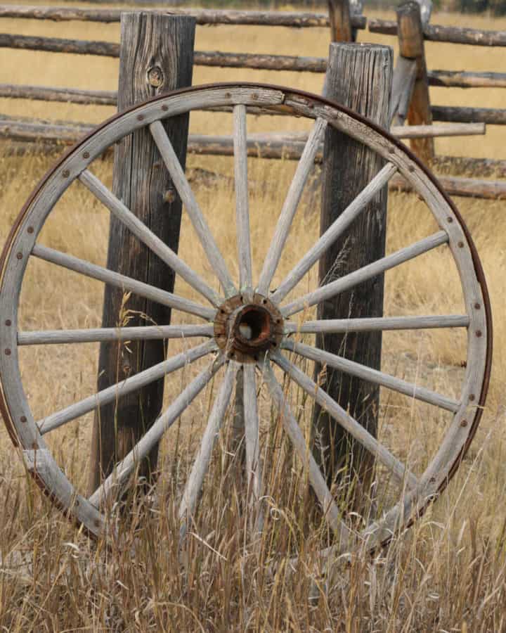 Historic Wagon wheel leaning against a fence post in Grant-Kohrs Ranch National Historic Site