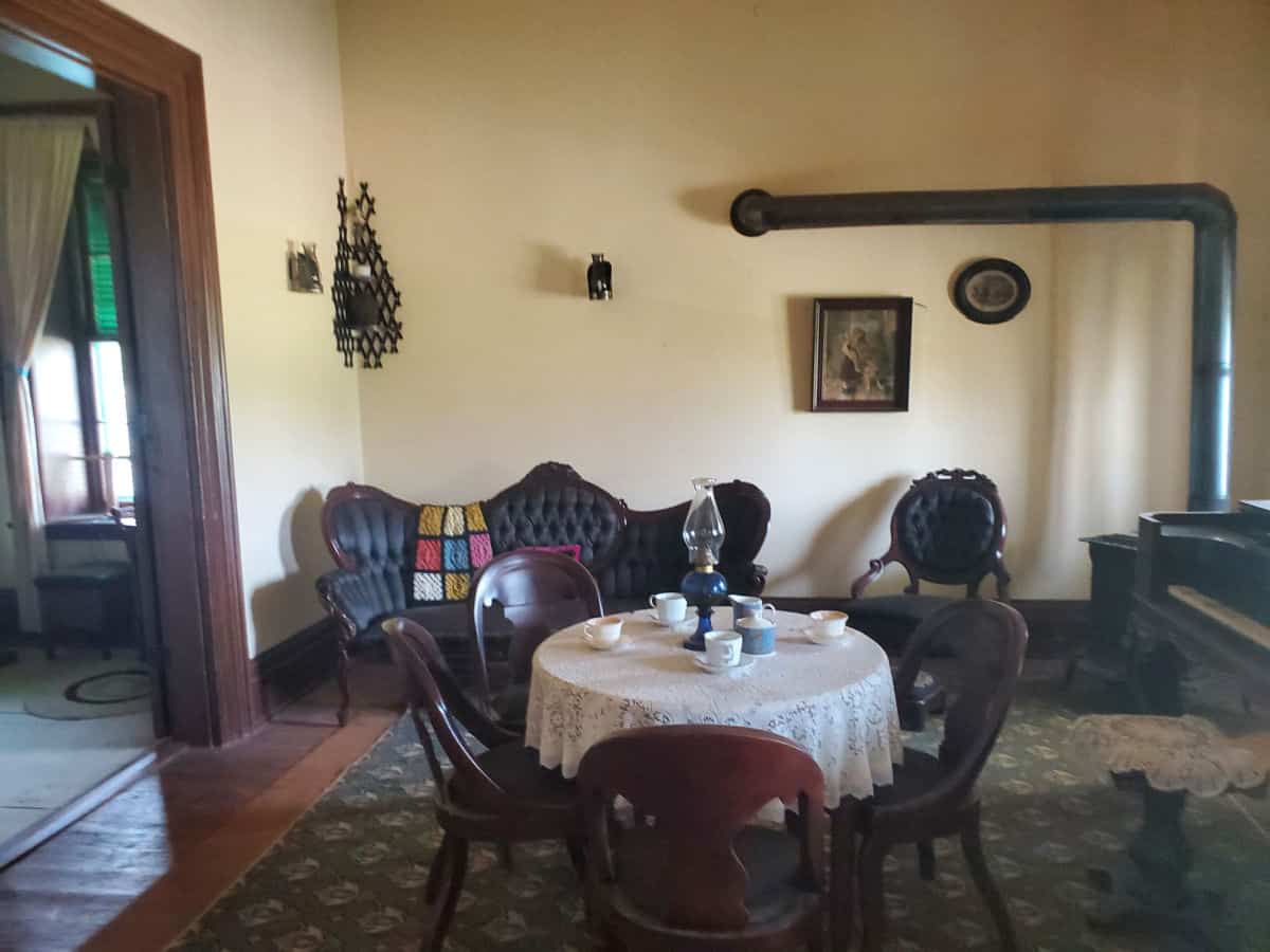 Fort Larned Historic Dining room with a kitchen table, fire place, couch, and wall decorations