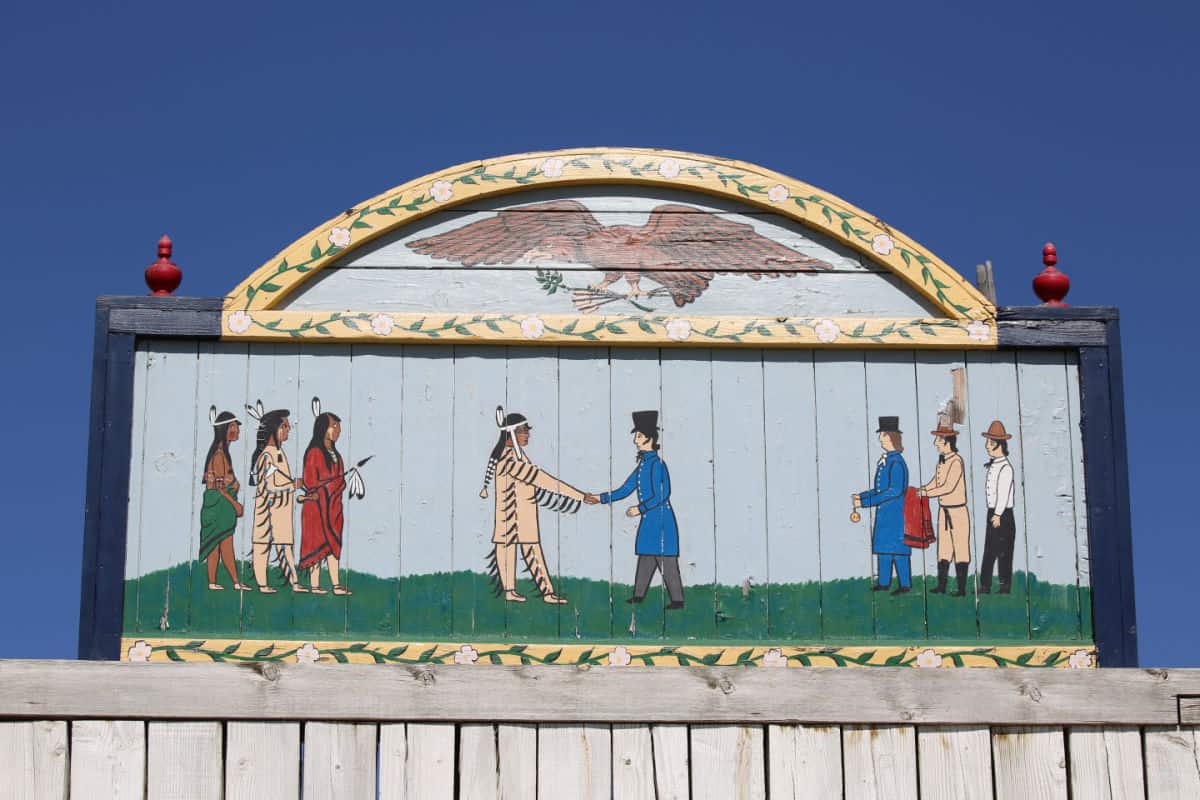 Historic painting with native americans meeting traders and shaking hands