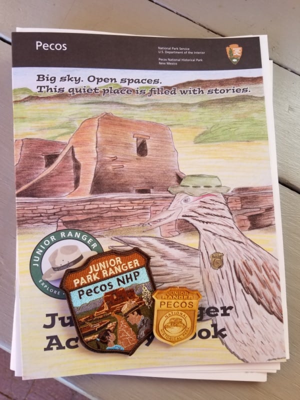 Pecos National Historical Park Junior Ranger booklet with a patch and wooden badge