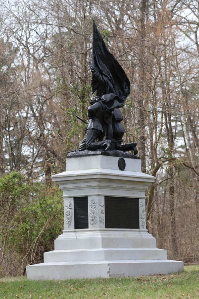 Large memorial sculpture with a flag and people kneeling. 