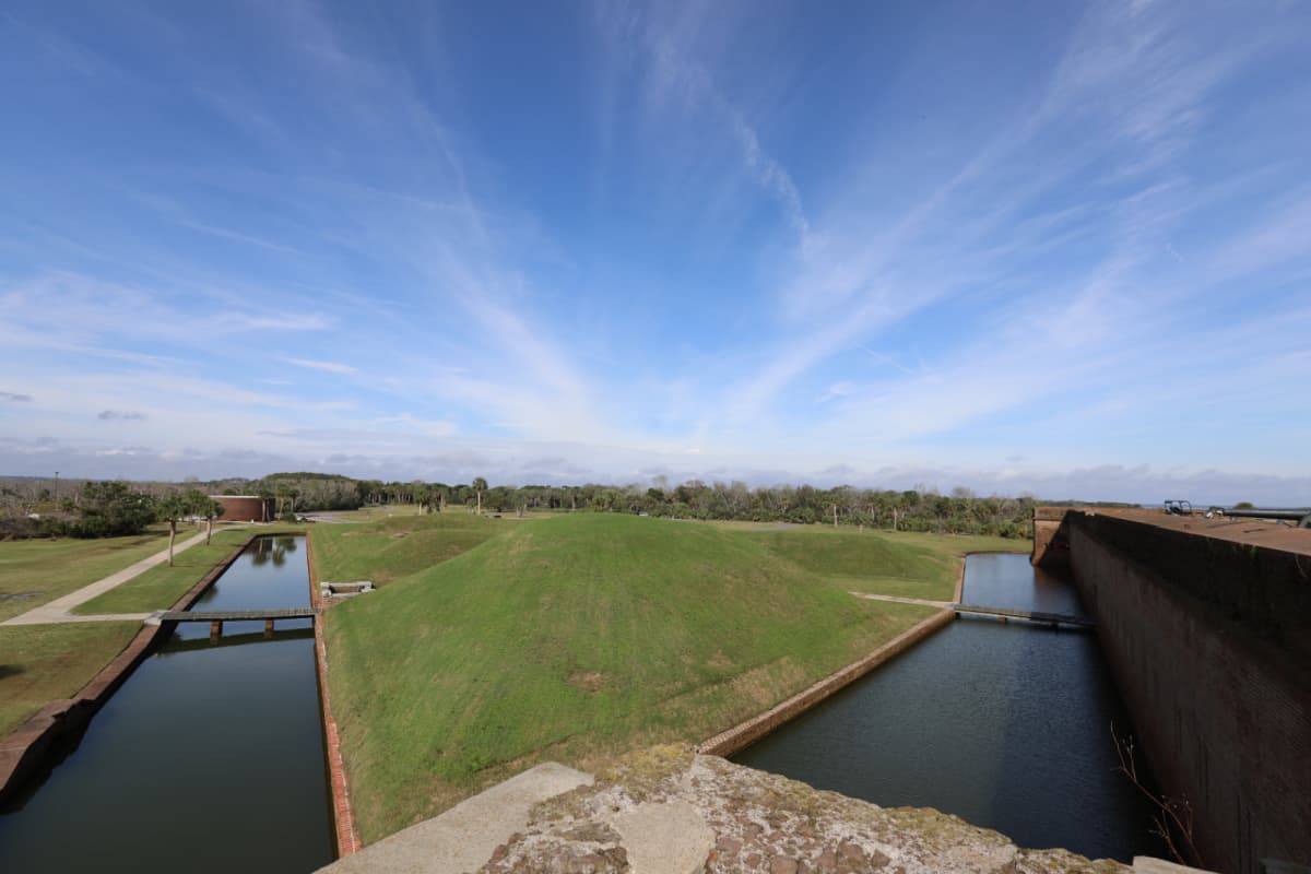 Moat surrounding Fort Pulaski with a green grass field