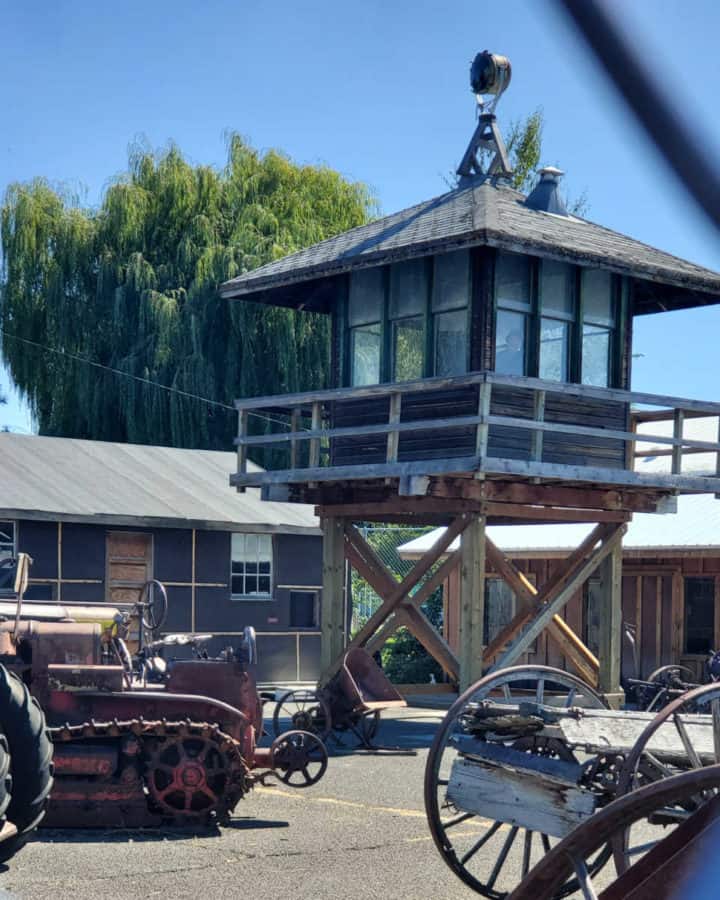 Tule Lake guard tower behind a fence with farm equipment