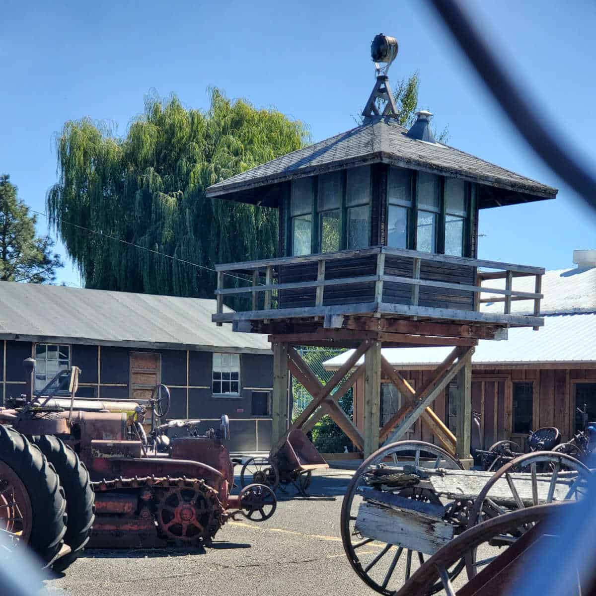 Tule Lake guard tower behind a fence with farm equipment 