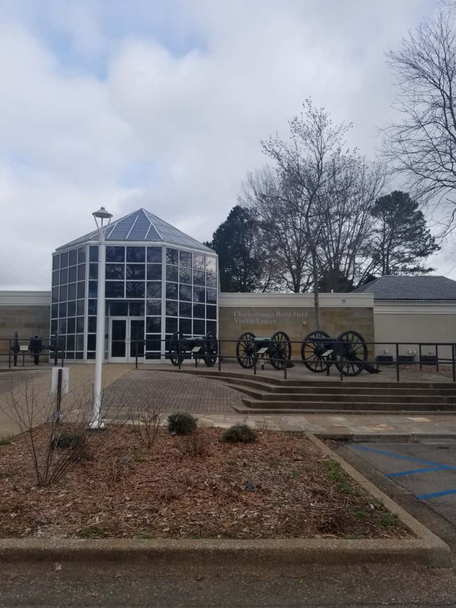 Cannons outside of the visitor center with large glass entrance 