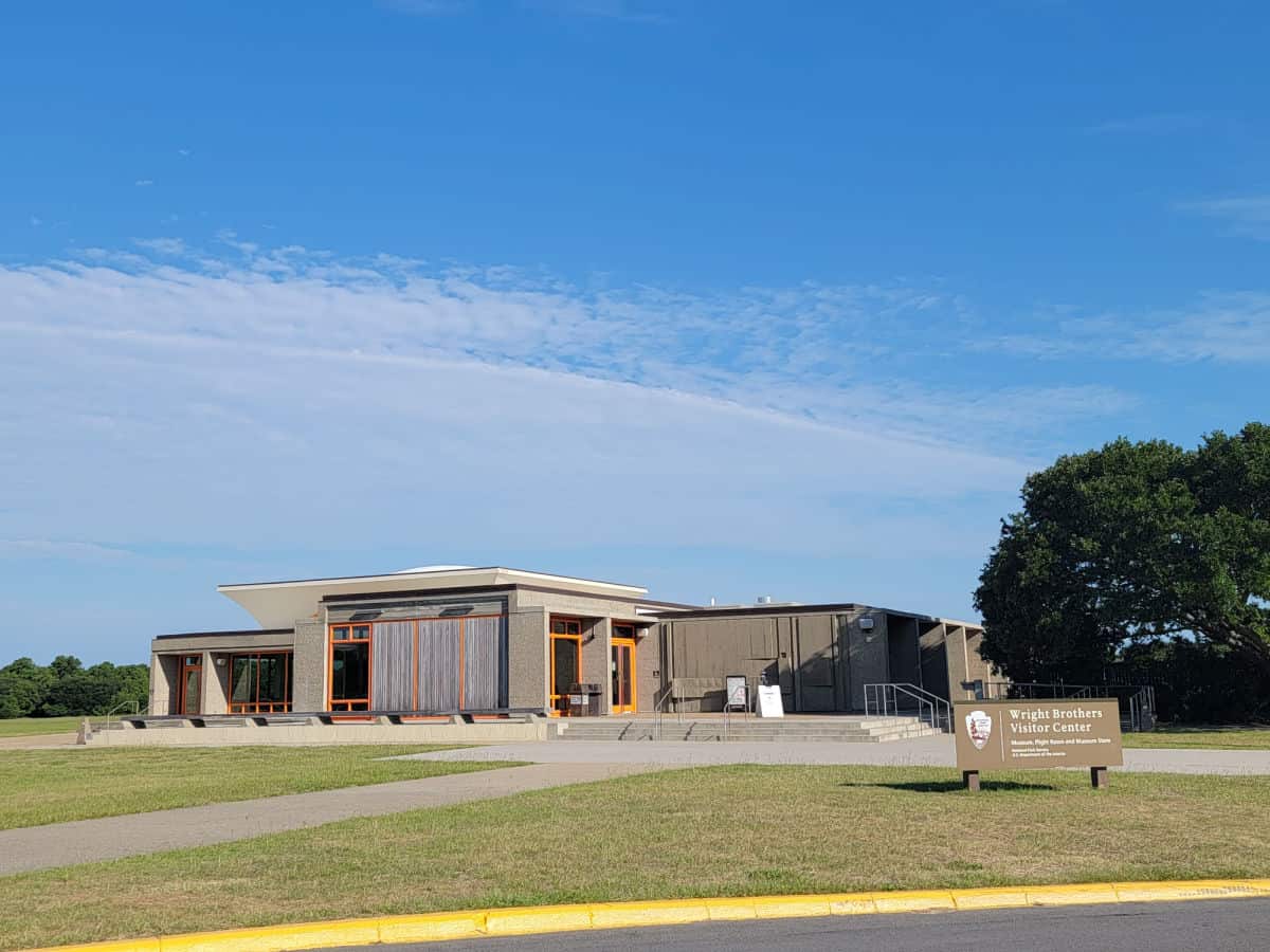 Exterior of the visitor center at Wright brothers national memorial with park sign