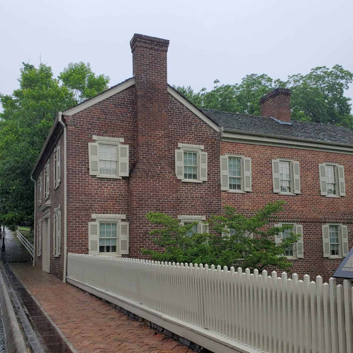 path leading to a historic brick home that is 2 stories