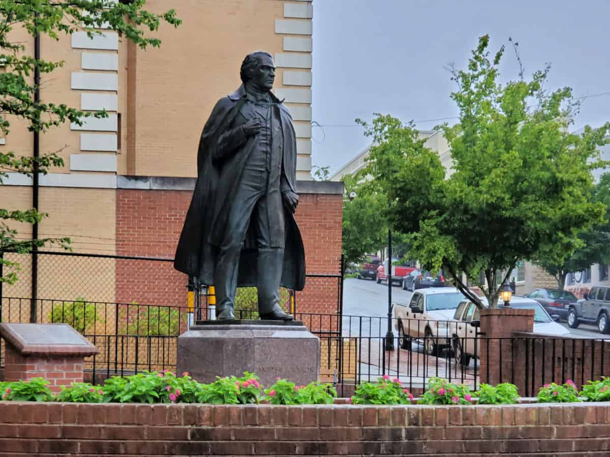 Statue of Andrew Johnson with trees and cars in the background