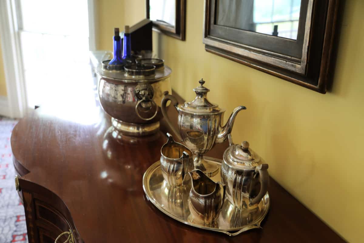 Antique coffee server on a platter on a wood banguet