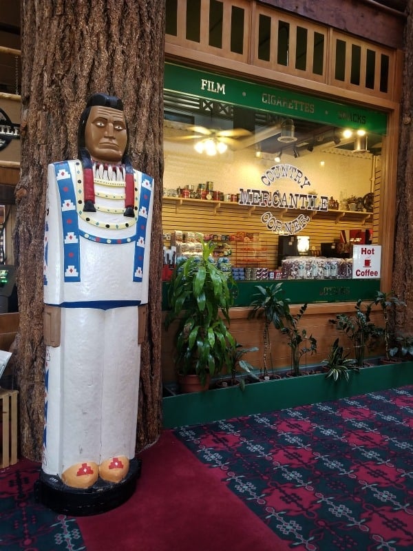 Wooden Native American statue outside of the Country Mercantile Corner, Glacier Park Lodge
