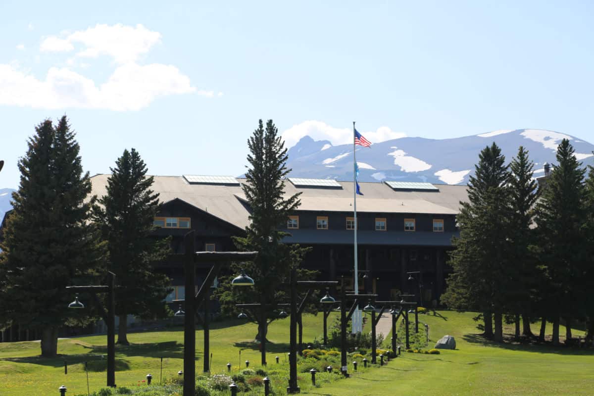 Flower path with lights leading to the Glacier Park Lodge and mountains in the background