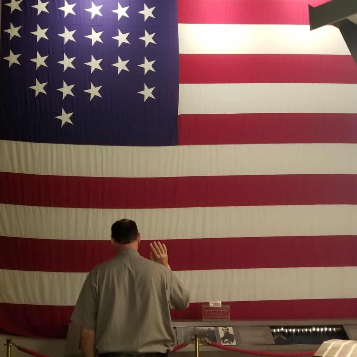 Park Ranger standing in front of a historic American Flag