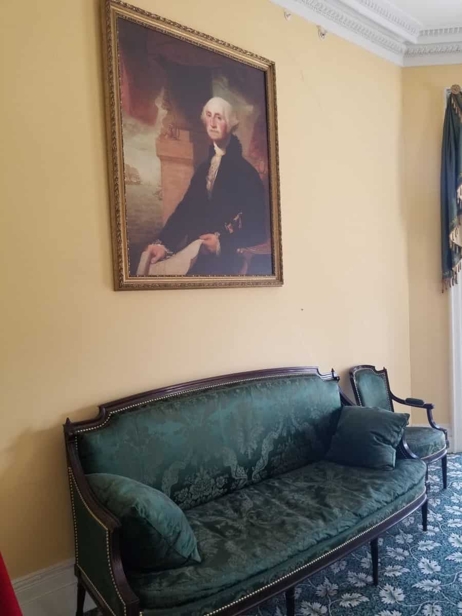 George Washington painting over a green couch
