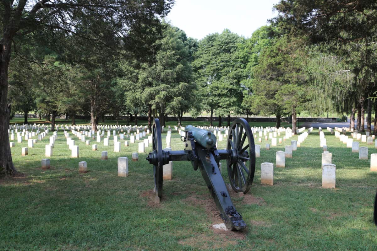 Historic cannon and cemetery with white headstones