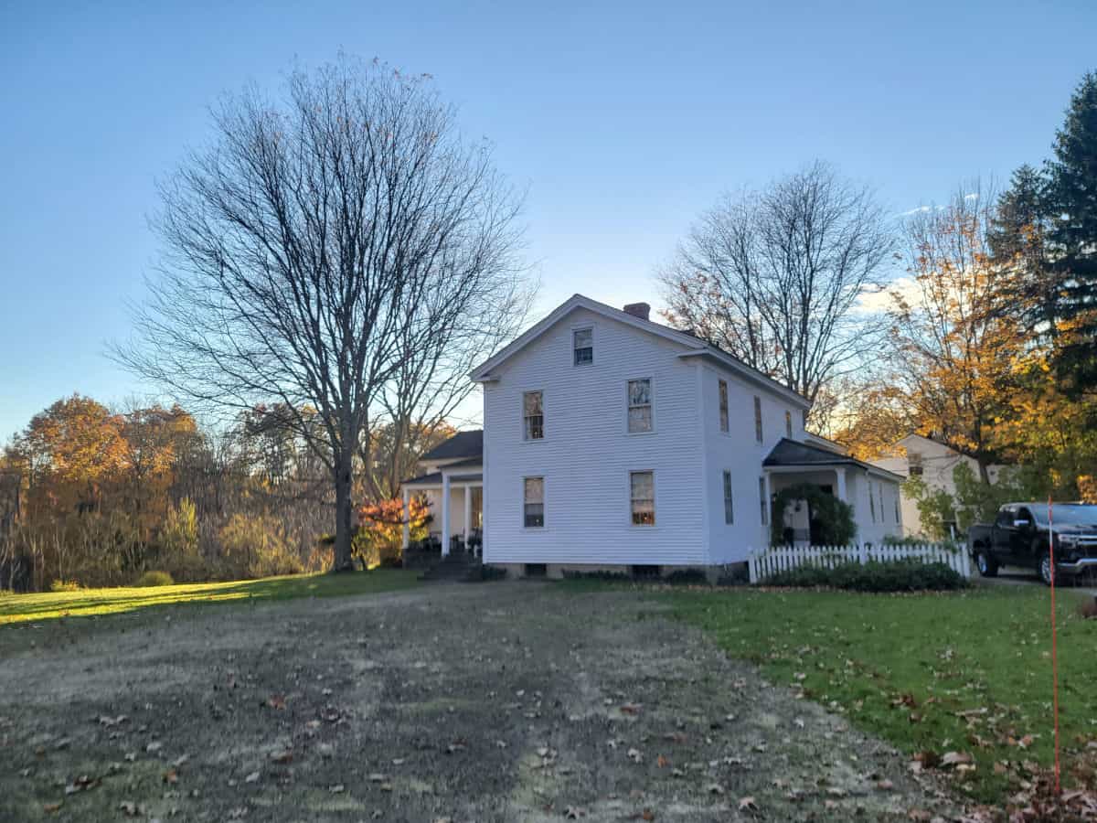 historic white inn with fall trees nearby