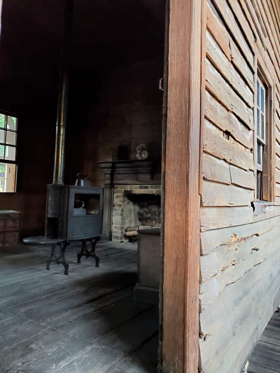 Looking into wooden cabin with a historic stove