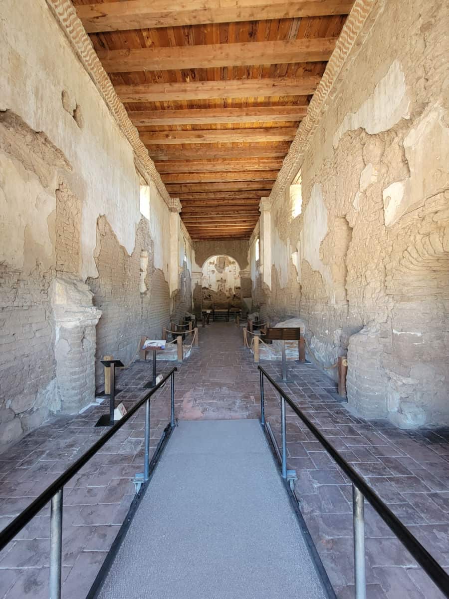 walkway into the mission interior with wood roof and stone walls