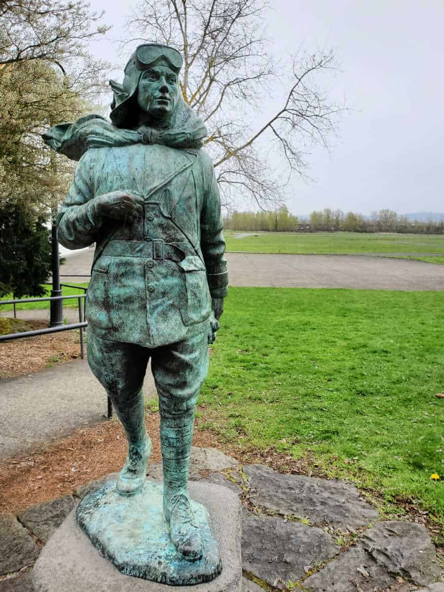 statue of a historic pilot with grass fields surrounding it