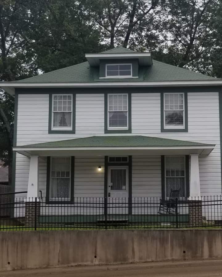 Exterior of two story Clinton Birthplace home with rocking chair on the porch